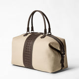 Front view: TRAVEL BAG IN CANVAS AND MOSAICO shown on a white background, natural canvas with an espresso Mosaico stripe, two rounded leather handles at the top.