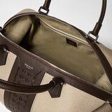 Detail view, TRAVEL BAG IN CANVAS AND MOSAICO: opened interior compartment shows natural-colored canvas lining and espresso-colored Mosaico and cashmere leather details, zipper and handle visible. Text: 'SERAPIAN MILANO'.