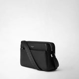 Frontal view: EAST WEST CROSSBODY BAG IN CACHEMIRE LEATHER lies at an angle, showing the front in black pebbled cachemire leather, braided shoulder strap, silver zipper; visible lettering: 'SERAPIAN MILANO'.