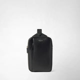Frontal view — SLING BACKPACK IN CACHEMIRE LEATHER AND MOSAICO shows a black, rectangular sling backpack made of grained Cachemire leather, placed frontally on a light background with visible 'SERAPIAN' logo.