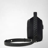 Frontal view — SLING BACKPACK IN CACHEMIRE LEATHER AND MOSAICO: Black rectangular sling backpack stands against a light background, showing an embossed Mosaico strap and fine pebbled cachemire leather.