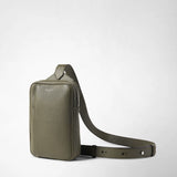 Frontal view: SLING BACKPACK IN CACHEMIRE LEATHER AND MOSAICO, olive green rectangular sling backpack standing on a light background, shoulder strap laid out; 'SERAPIAN' visible on front.