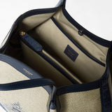 Detail view: SECRET TOTE BAG IN DENIM AND RAFFIA shows an open interior compartment with a central zip pocket, beige textile lining, navy leather trim, and visible 'SERAPIAN MILANO' embossing.