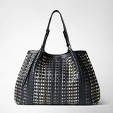 Front view of the MAXI SECRET TOTE BAG IN MOSAICO MESTIERI D'ARTE with black, yellow, and white pattern, long adjustable handles, and visible mini pochette.