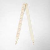Front view: SHOULDER STRAP IN MOSAICO MESTIERI D'ARTE displayed lengthwise, showing cream-colored Mosaico leather with pink triangular insets and gold carabiner ends on a light background.