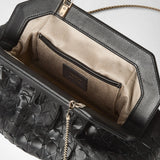 Vista dettagliata: CLUTCH SECRET IN MOSAICO aperta, vista frontale; fodera interna beige, tasca interna e catena dorata visibili, esterno in nappa Mosaico nera intrecciata. Sull'etichetta interna: "SERAPIAN MADE IN ITALY".