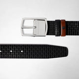 Frontal view: REVERSIBLE BELT IN STEPAN 72 shows a black textured belt with a gunmetal buckle and a brown leather accent loop, lying flat on a light background.