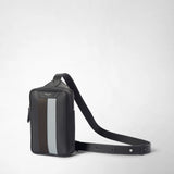 Front view: SLING BACKPACK IN STEPAN stands upright and displays an embossed asphalt-gray pattern, ebony and ice-blue leather strips, and a long shoulder strap; against a light studio background. Visible lettering: “SERAPIAN MILANO”.