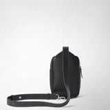 Rear view: The SLING BACKPACK IN STEPAN features an embossed asphalt-gray pattern and a wide leather strap; the adjustable shoulder strap is laid out against a light background.