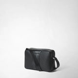 Frontal view: CAMERA CROSSBODY BAG IN STEPAN lies slightly askew on a white background; black, S-etched Stepan coated canvas with leather bands, zipper, and an adjustable shoulder strap. Visible text: 'SERAPIAN MILANO'.